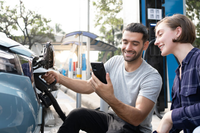 Junge Menschen laden ein Elektroauto